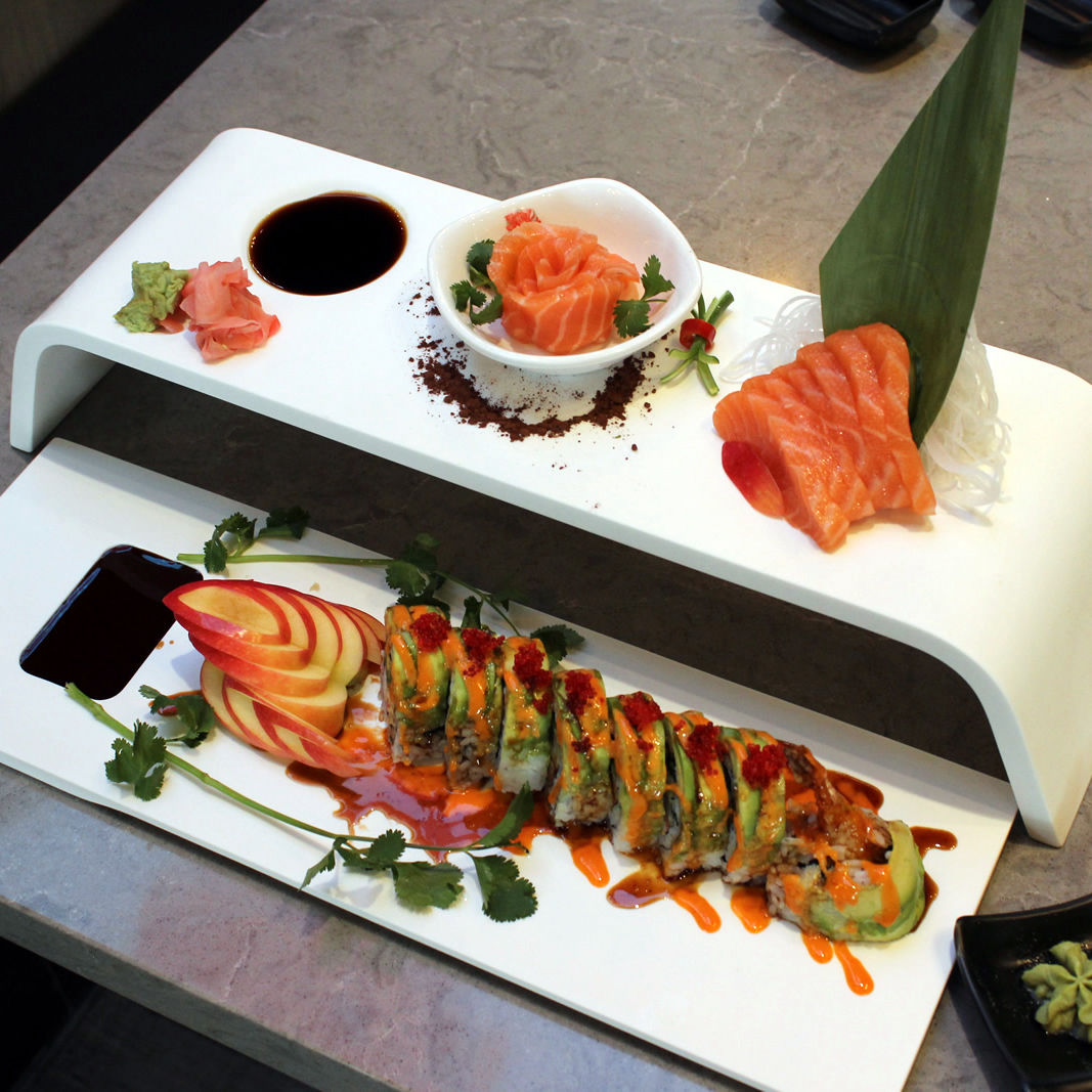 Minimalist Sushi Trays with maki and sashimi on display.